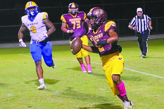 Crescent City quarterback Eric Jenkins Jr. seeks a receiver as Newberry’s Mykah Newton chases him. (RITA FULLERTON / Special to the Daily News)