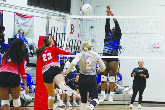 Bradford’s Harli Mosley (23) attempts to put a kill past Interlachen’s Ni’Aira McCaskill in the first set of Tuesday’s semifinal match at Bradford High as Interlachen coach Tonya Troiano (right) looks on. (MARK BLUMENTHAL / Palatka Daily News)