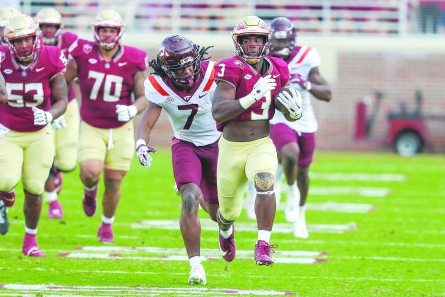 Florida State’s Trey Benson tries to outrace Virginia Tech’s Keonta Jenkins during Saturday’s game at Doak Campbell Stadium. (GREG OYSTER / Special to the Daily News)