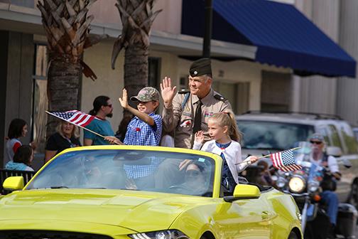 SARAH CAVACINI/Palatka Daily News.  Retired Army veteran Lt. Col. Charles Coxsell and his family wave to Veterans Day parade attendees down St. Johns Avenue as he serves as the Veterans Day parade's grand marshal.  