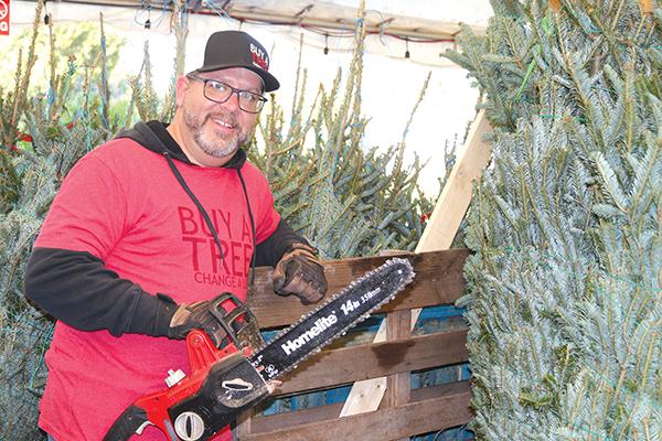 TRISHA MURPHY/Palatka Daily News – Steve Burkowske, the site director for Buy A Tree Change A Life – Palatka, gets ready to trim a Christmas tree that will be for sale at Open Door Church of God, 3704 Crill Ave. in Palatka.