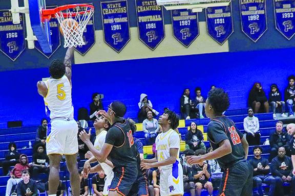 Palatka’s Trenton Williams (left) goes in for a layup Tuesday night in the Panthers’ win over Jacksonville Atlantic Coast. (RITA FULLERTON / Special to the Daily News)