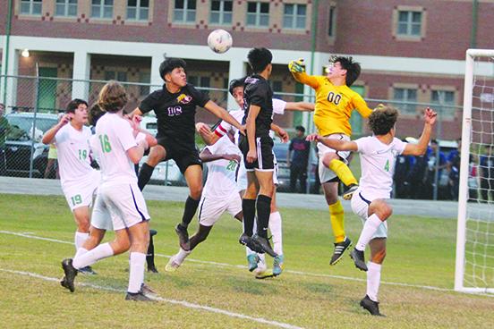 Father Lopez High School boys soccer goalkeeper Leo Spears (00) knocks the ball away from a headball attempt by Crescent City’s Bryan Garcia (16) during Thursday’s game. (MARK BLUMENTHAL / Palatka Daily News)
