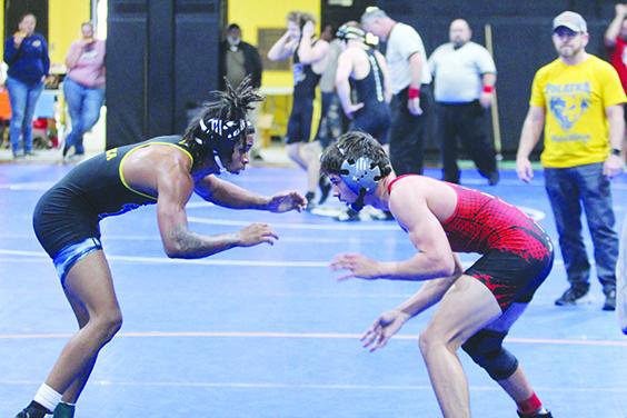 Palatka's Ishmael Foster (left) does battle with Baker County's Tax Kinghorn during the District 4-1A 132-pound championship. In the background at right is Palatka head coach Josh White. (MARK BLUMENTHAL / Palatka Daily News)