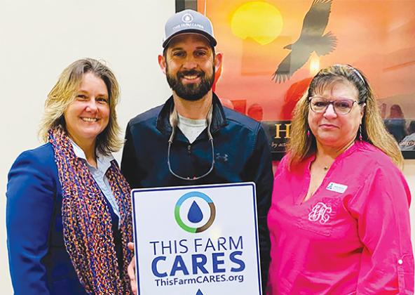 Submitted by Jackie Fazzolari – Wendy Mussoline, left, and Jackie Fazzolari, right, celebrate Jon William Revels, center, for being recognized by the Putnam County Board of Commissioners for receiving the Florida Farm Bureau’s This Farm Cares Award.