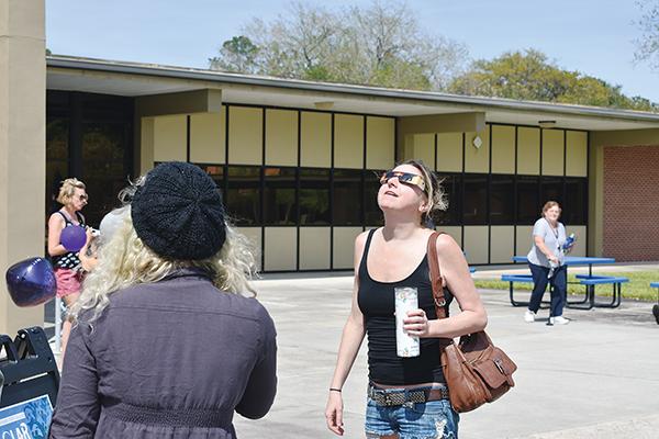 BRANDON D. OLIVER/Palatka Daily News – A woman wearing special glasses looks at the solar eclipse Monday.