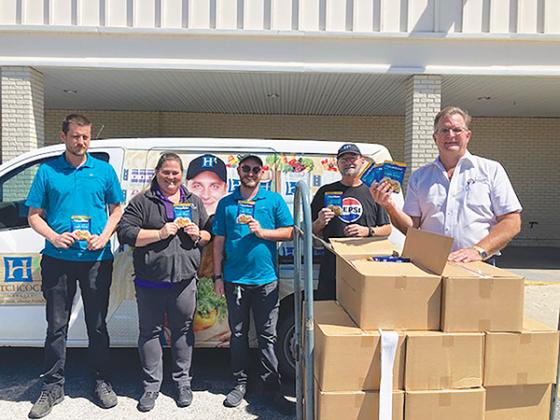 Photo submitted by Larry Havey – County Commissioner Larry Harvey, right, stands with employees of Hitchcock’s Market in Interlachen on Monday after purchasing more than 2,000 tuna packets to donate to Feed the Need of Putnam County.
