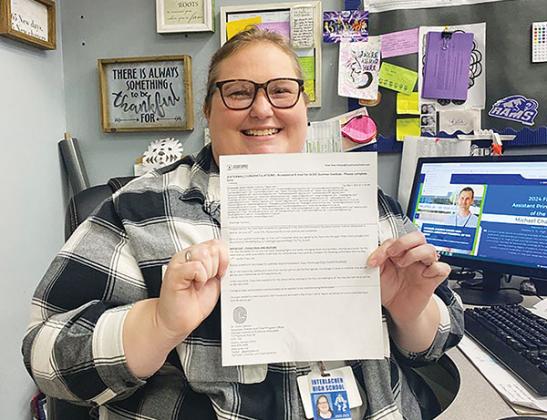 Photo courtesy of Interlachen Junior-Senior High School – Katie Hess, an economics teacher at Interlachen Junior-Senior High School, holds the letter informing her she has been accepted to attend a conference in Georgia this summer.