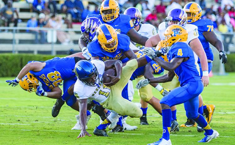 A host of Panthers upend Menendez quarterback King Benford in the first half of their game last Friday night. (FRAN RUCHALSKI / Palatka Daily News)