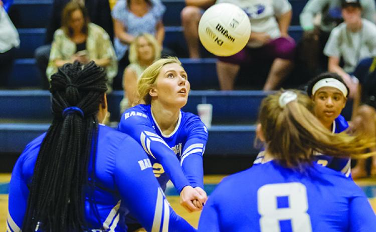 Interlachen High School's Kirby Mason (2) pops the ball back over the net in the first set of their match against Palatka.