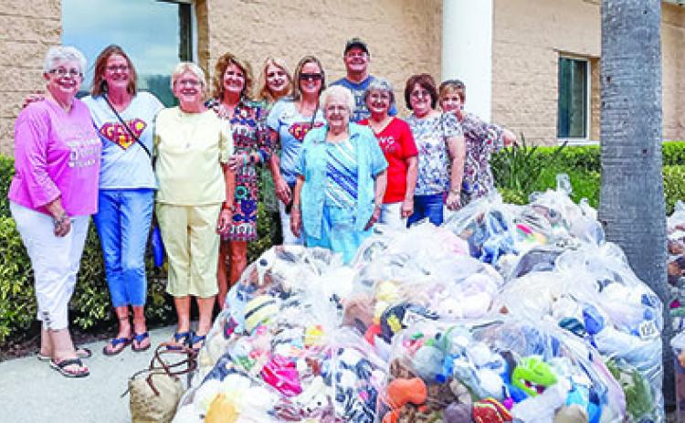 Woman's Club of Palatka members stand with bags of toys they're donating for children in crisis. 