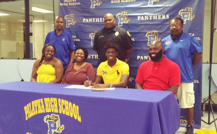 Two-time Daily News Boys Basketball Player of the Year Malik Beauford of Palatka High School is all smiles as he signs his letter of intent Monday to attend classes and play the sport at Lane College in Tennessee. Sitting in the front, from left, are his sister, Makayla, mother Devona, and father Terrance. In the back row, from left, are Palatka High assistants Eugene Blye and Jason Shaw and head coach Bryant Oxendine. (MARK BLUMENTHAL / Palatka Daily News)