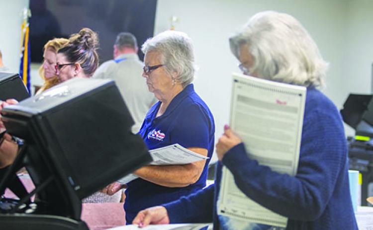 On Friday, election workers Dorothy Cooper and Carlene Mims insert test ballots into machines used in Putnam County elections