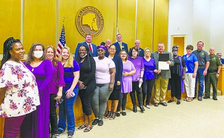 Domestic vioence advocates for Lee Conlee House stand with local law enforcement and the Board of County Commissoners during a board meeting last week.
