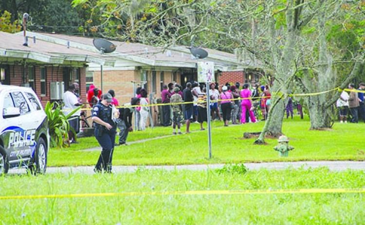 A crowd gathers Tuesday as police investigate the area of 17th and Olive streets, where a dead body was found that morning.
