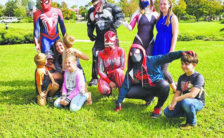 Johnathan Garcia and other volunteers dress up Saturday and take pictures with local children ahead of Halloween.