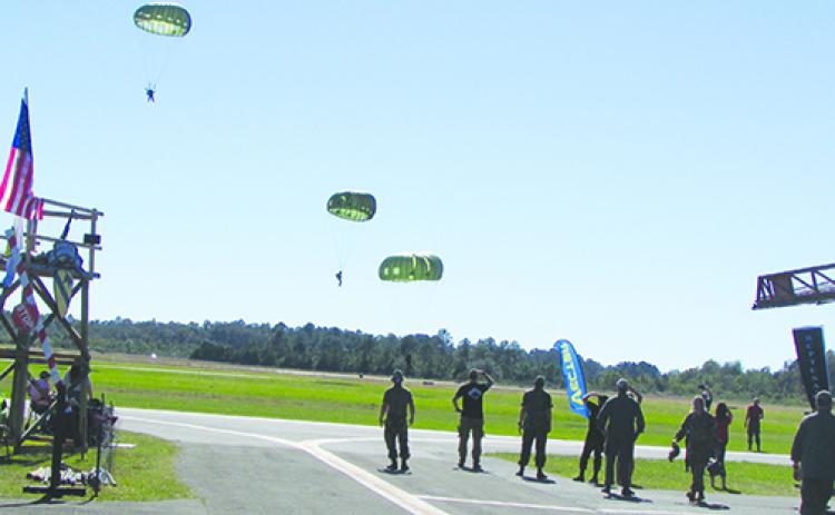 Paratroopers land at Kay Larkin Field on Friday afternoon after jumping from a Huey helicopter as part of Operation Black Cat IV honoring Vietnam veterans. 
