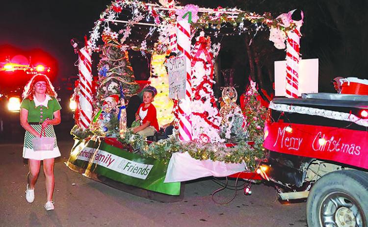 Participants in last year’s Christmas parade in Interlachen hand out candy. The town plans stationary parade floats this year and fireworks as part of its Christmas celebration.