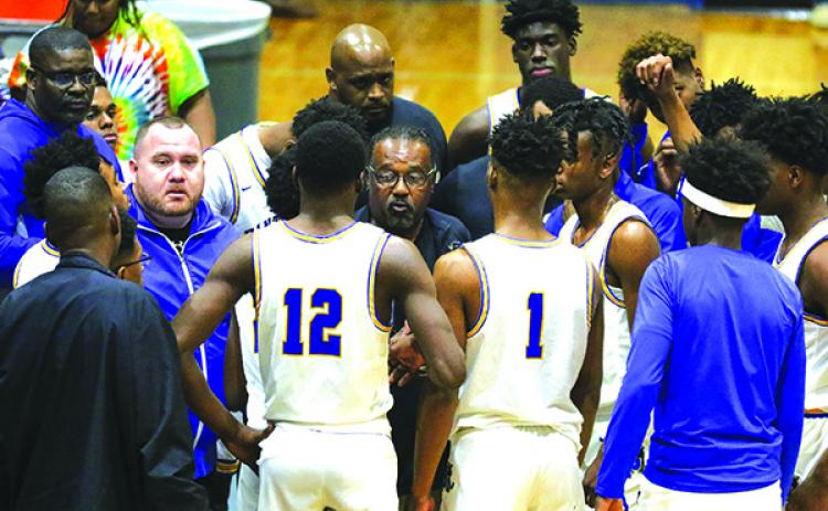 Bryant Oxendine (center) talks with his Palatka High School boys basketball players during a timeout last February. Oxendine stepped down as head coach on Tuesday and was replaced by main assistant coach Bryan Walter (on Oxendine’s right). (GREG OYSTER / Special To The Daily News)