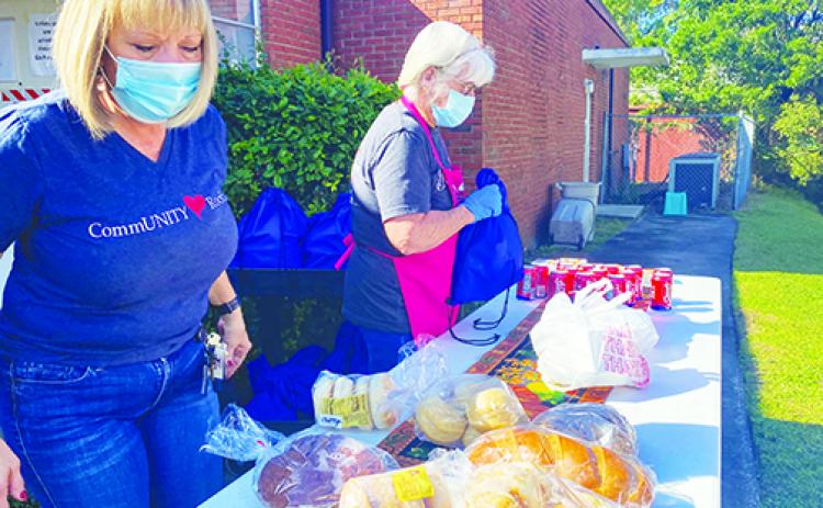 Bread of Life Community Resource Liaison Kim Daley and Dream Team Kitchen ManagerTerri Sorrell hand out food to residents in need Wednesday at First Presbyterian Church of Palatka.