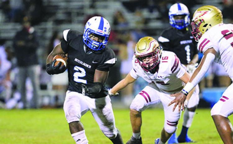 Interlachen High running back Gary Armstrong tries to avoid the tackle attempts of Episcopal School’s Bruce Jackson, 16, and Elijah Franklin during the first half Friday night.
