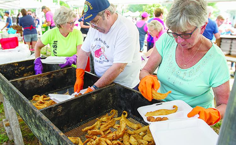 Catfish Festival vendors fry up and plate fish during the 2019 event.