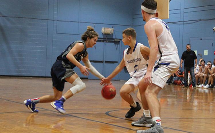 Bunnell First Baptist Christian point guard Jeremiah Smith dribbles late in Thursday’s game against Peniel Baptist Academy against defender Trae Jenkins as teammate Jeremiah Sweet backs up behind Jenkins. (MARK BLUMENTHAL / Palatka Daily News)