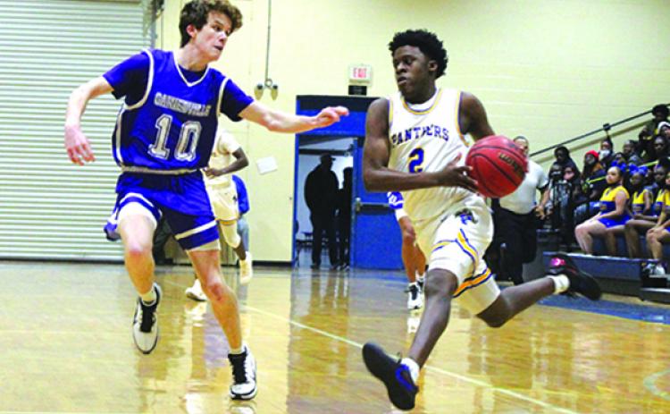 Palatka High School’s Vanari Johnson (right) takes the ball to the basket against Gainesville High’s Cal Evans during Tuesday night’s game. (MARK BLUMENTHAL / Palatka Daily News)