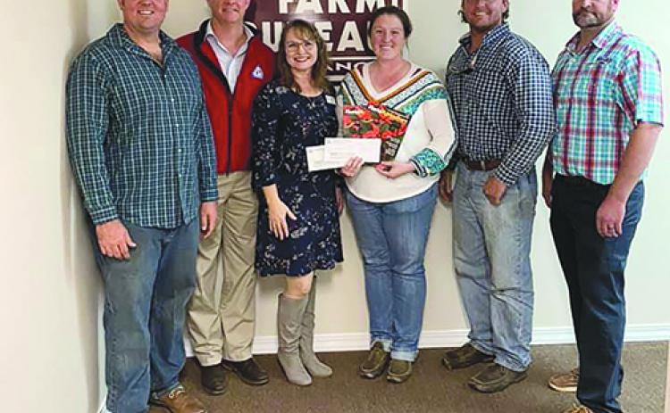 Palatka High School agricultural sciences teacher Alexis Tilton, third from right, hold checks she received from the Putnam-St. Johns Farm Bureau board of directors and the Florida Farm Bureau for her classroom.
