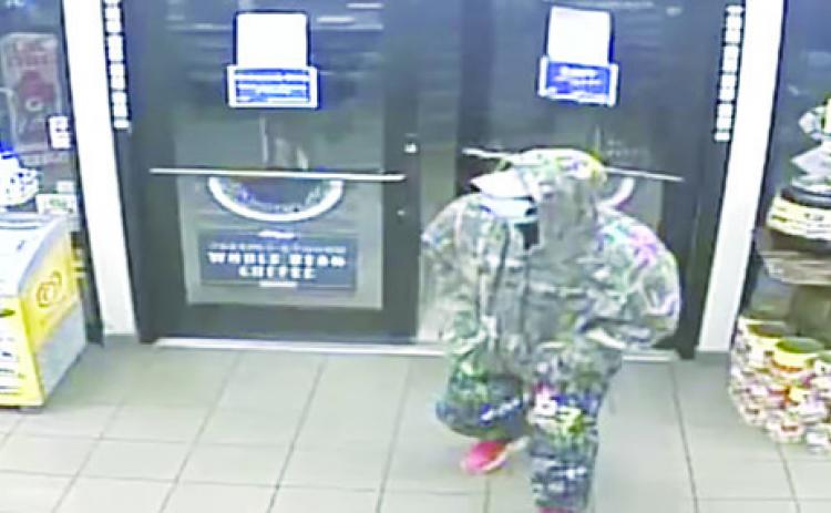 A camo-clad man is seen in surveillance footage moments before he used a gun to rob an East Palatka convenience store, authorities said.