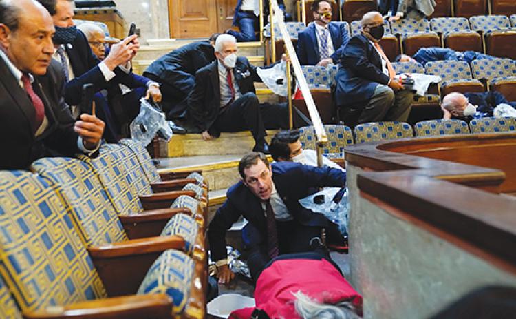 People shelter in the House gallery as protesters try to break into the House Chamber at the U.S. Capitol on Wednesday in Washington.