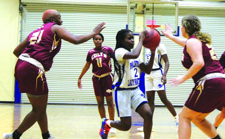 Palatka’s Zyria Jones goes between North Marion’s Jermaya Jackson (21) and Sophie Watson (right) during Monday night’s game. (MARK BLUMENTHAL / Palatka Daily News)