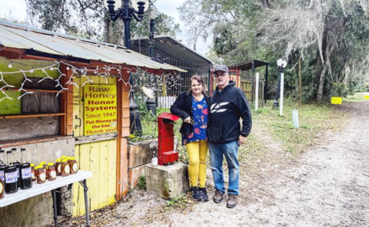 Scott and Elaine McMillin, owners of The Honey Stand in San Mateo, stand next to the roadside business, which has been a local favorite for years.