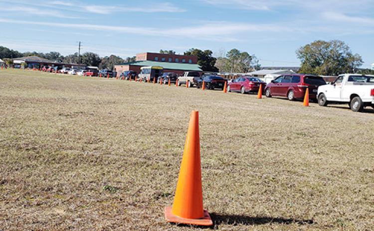 Dozens of cars wrap around the Putnam County COVID testing site in Palatka this week as the number of people diagnosed since the holidays has soared.