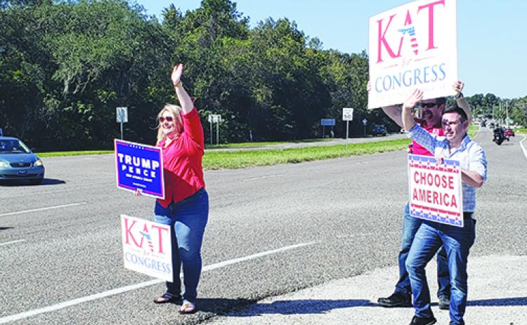 Kat Cammack waves to motorists before the 2020 general election.