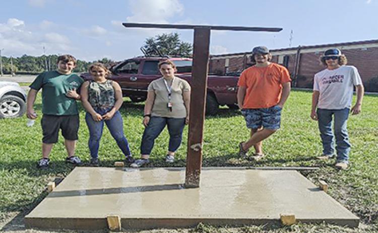 Crescent City High JROTC cadets stand near the foundation for a new sign at the high school that, when completed, would feature an arrowhead painted in the school’s colors.