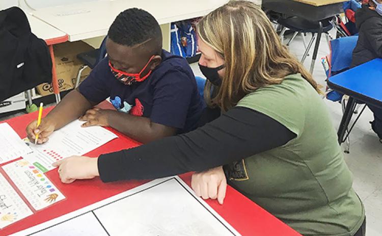 Jennifer Rawski, Putnam County School District’s School-Related Employee of the Year, assists a Mellon Elementary School student Thursday.