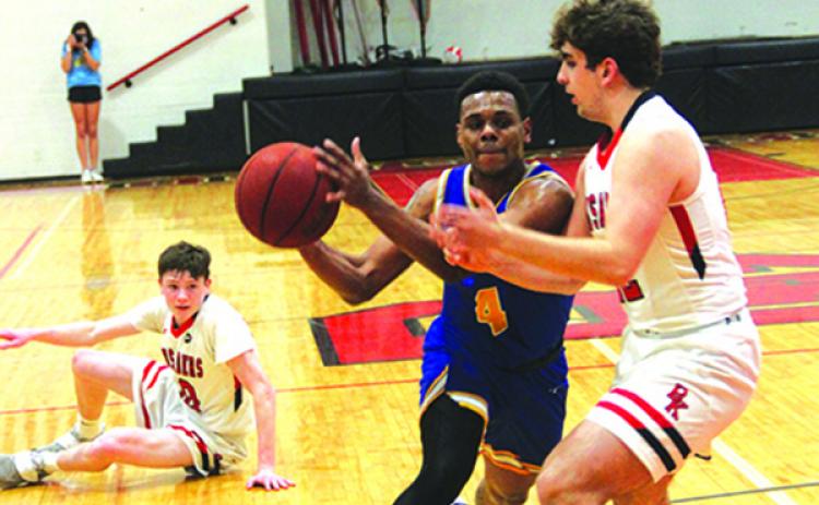 Palatka’s Jimmie Williams drives to the basket against Bishop Kenny’s Will Haen with Kenny teammate Daniel Buckley left behind on the ground in Wednesday’s game. (ANTHONY RICHARDS / Palatka Daily News)