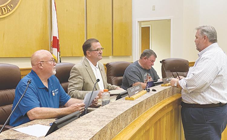 From left, then-County Commissioner Buddy Goddard, Commissioners Larry Harvey and Jeff Rawls, and County Administrator Terry Suggs discuss upcoming COVID-19 protocols during an emergency meeting in March 2020.