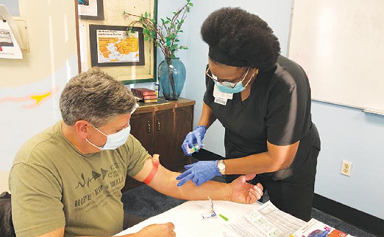 Nelda Thomas draws blood from Bobby Daley recently as part of the Rotary Club of Palatka’s 25th annual Blood Screening. Daley credits a screening 20 years ago to discovering he had prostate cancer. 