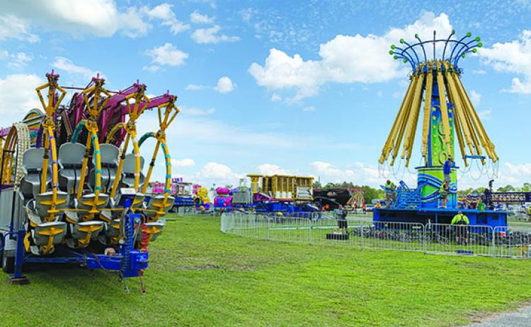 Deggeller Attractions employees assemble rides Tuesday at the Putnam County Fairgrounds in East Palatka.