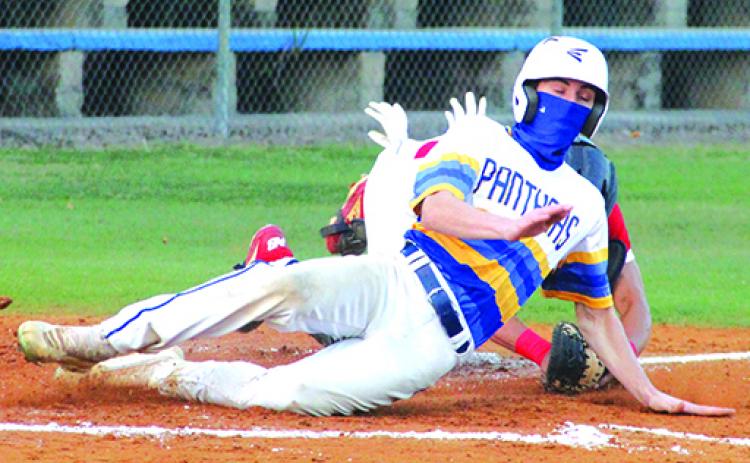 Palatka’s Trace Ogle crosses home plate ahead of the tag of Pierson Taylor High catcher Federico Rubio on a first-inning passed ball. (ANTHONY RICHARDS / Palatka Daily News)