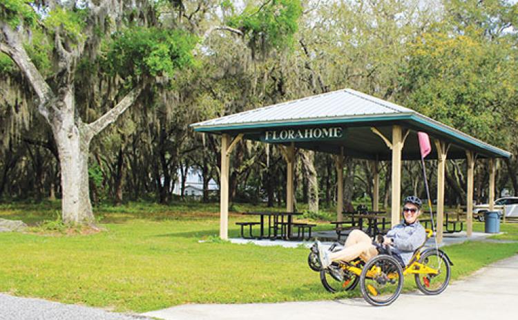 Meri-lin Piantanida, president of the Florahome Park and Heritage Association, takes a break from riding her bike in front of the Florahome Community Park pavilion last month. 