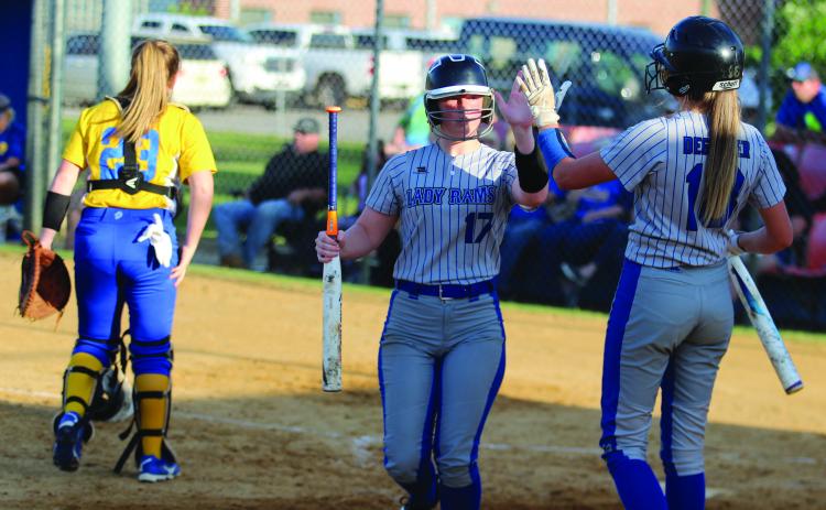 Interlachen’s Halie Gutierrez (left) is greeted by teammate Briana Degeyter after scoring the first run of the game on a Janae Green double in the second inning. (MARK BLUMENTHAL / Palatka Daily News)