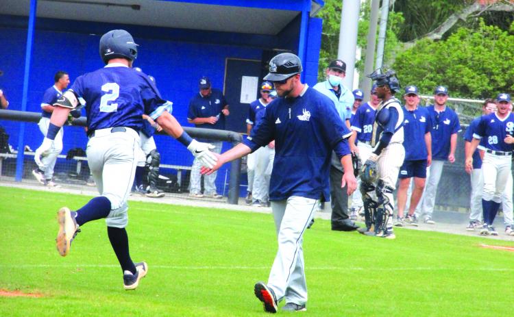St. Johns River State’s Chase Malloy is congratulated by assistant coach Morgan Depew as he rounds third after his solo home run in the third inning. (ANTHONY RICHARDS / Palatka Daily News)