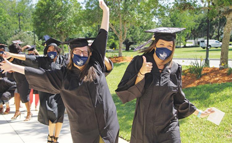 Radiologic technology graduates Cheyenne Walker and Hollie Harrell of Putnam County and Mallory Pierce of Clay County celebrate during their march into the St. Johns River State College spring graduation ceremony Friday.