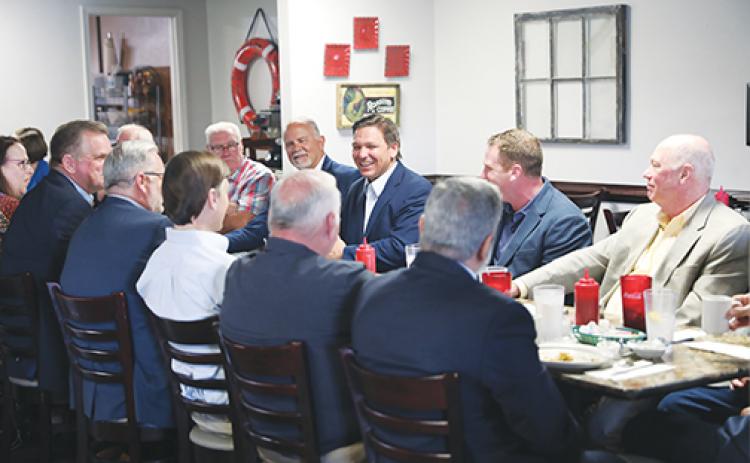Gov. Ron DeSantis, center, converses with Putnam County business and government leaders during breakfast Monday morning in Palatka.