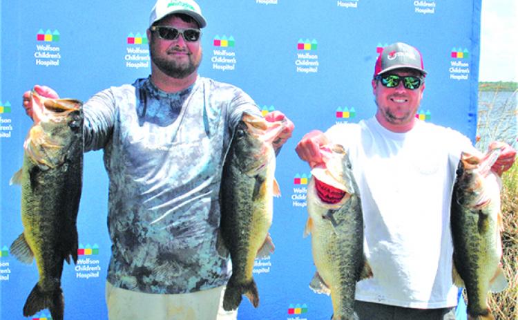 Will Scaife (left) and Branden Waters show off some of their catch in winning Saturday’s bass tournament with 30.66 pounds. (GREG WALKER / Daily News correspondent)