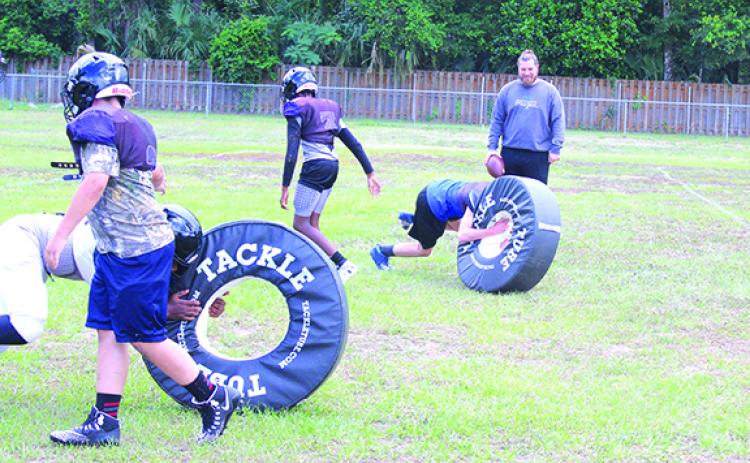 Peniel Baptist Academy six-man football coach Jonathan Goodwin (right) watches his players go through a tackling drill during the team’s final day of practice on May 21. (MARK BLUMENTHAL / Palatka Daily News)