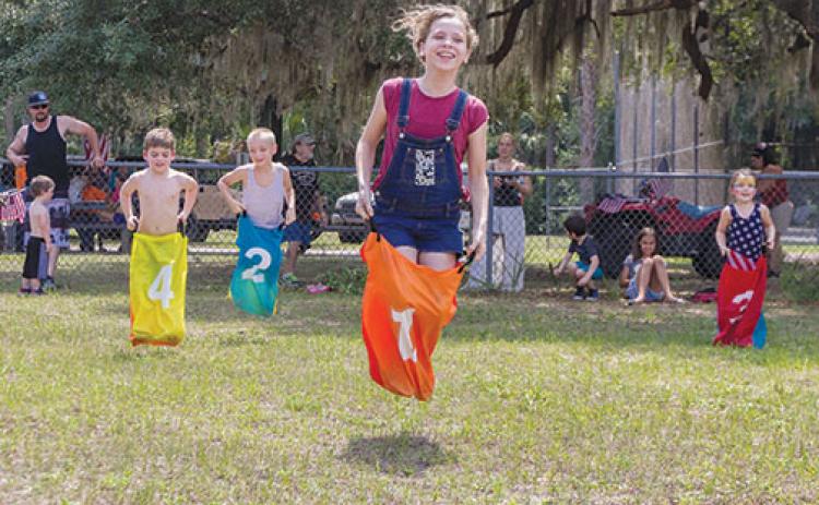 Children hop up and down as they compete in the sack race during Interlachen’s Independence Day Celebration in 2019.